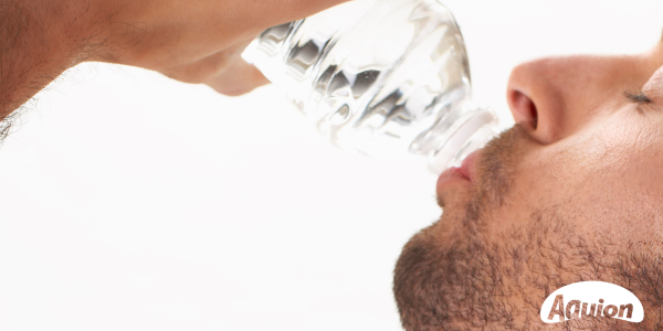 Mann trinkt aus Wasserflasche. WasserstoffWasser Aquion